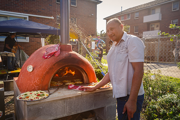 A tenant cooking pizza in the pizza oven