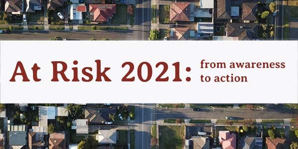 At Risk 2021 From awareness to action, aerial view of houses behind banner