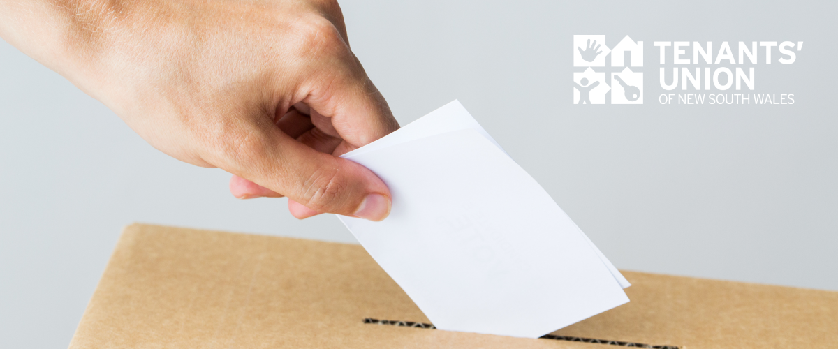 Hand placing a piece of paper into a brown ballot box. Tenants' Union logo in the top right hand side of the image.