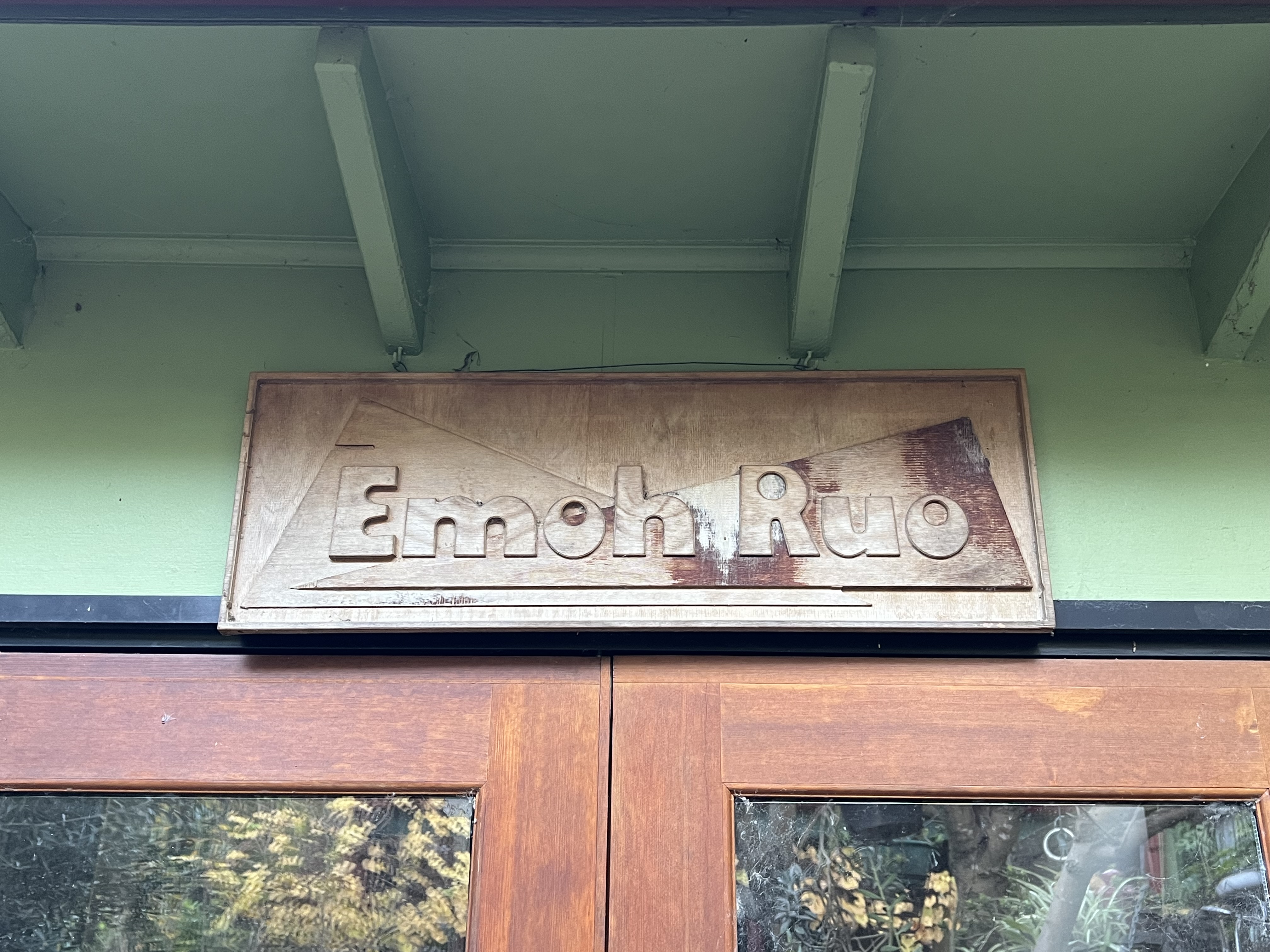 A sign above a door reads "Emoh Ruo"