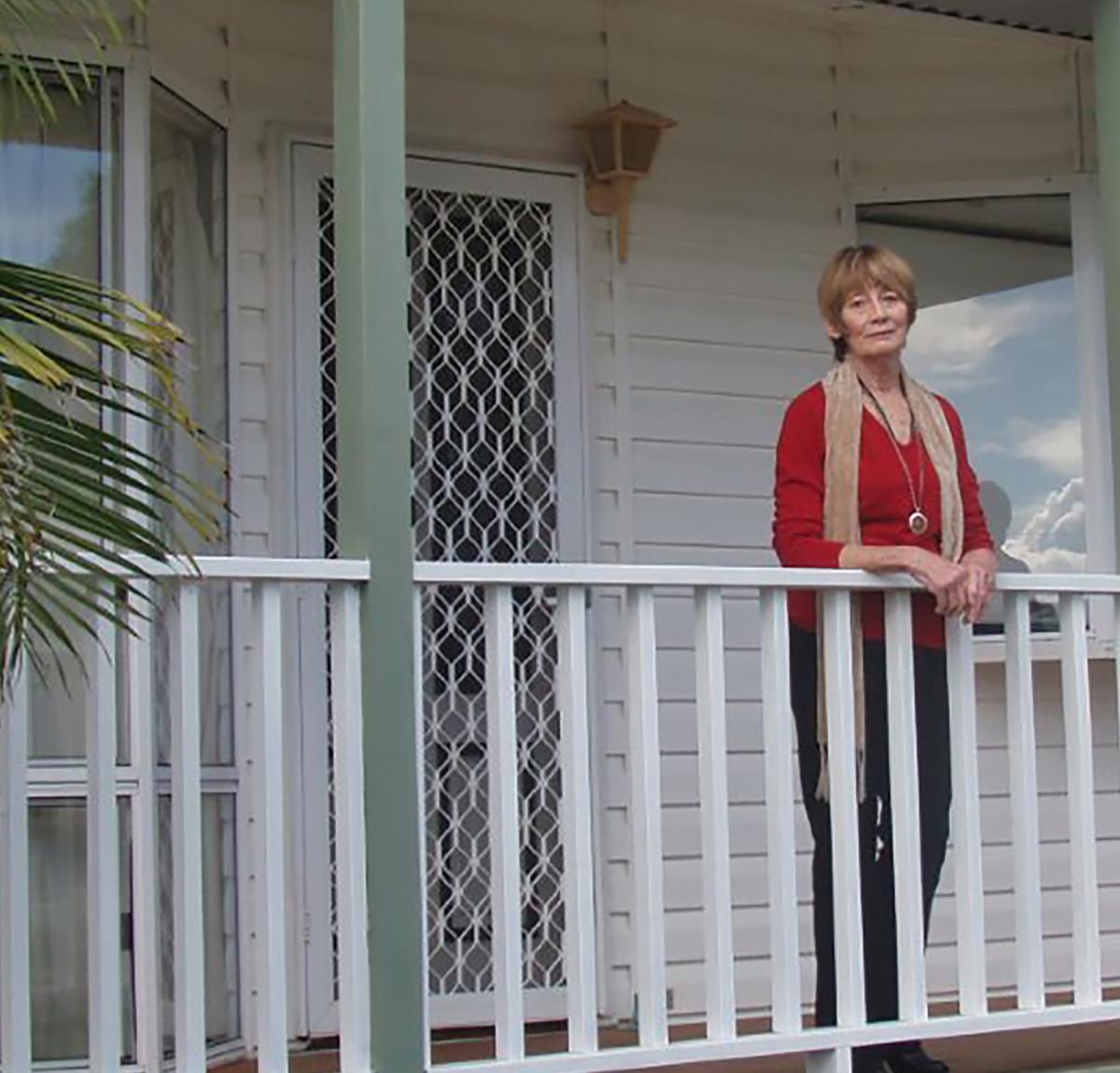 Woman standing on the deck of a dwelling in a residential land lease community