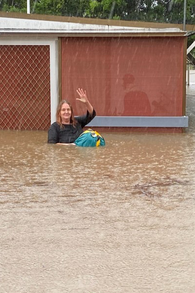 woman in flood waters waiting to be rescued