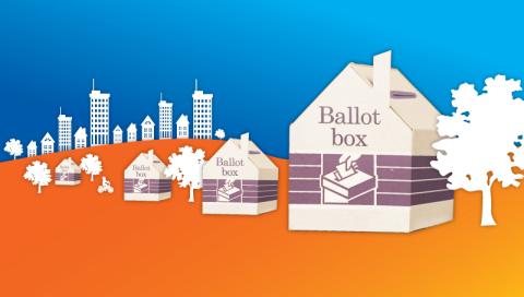 ballot boxes in the shape of houses, on a background of blue sky and orange ground