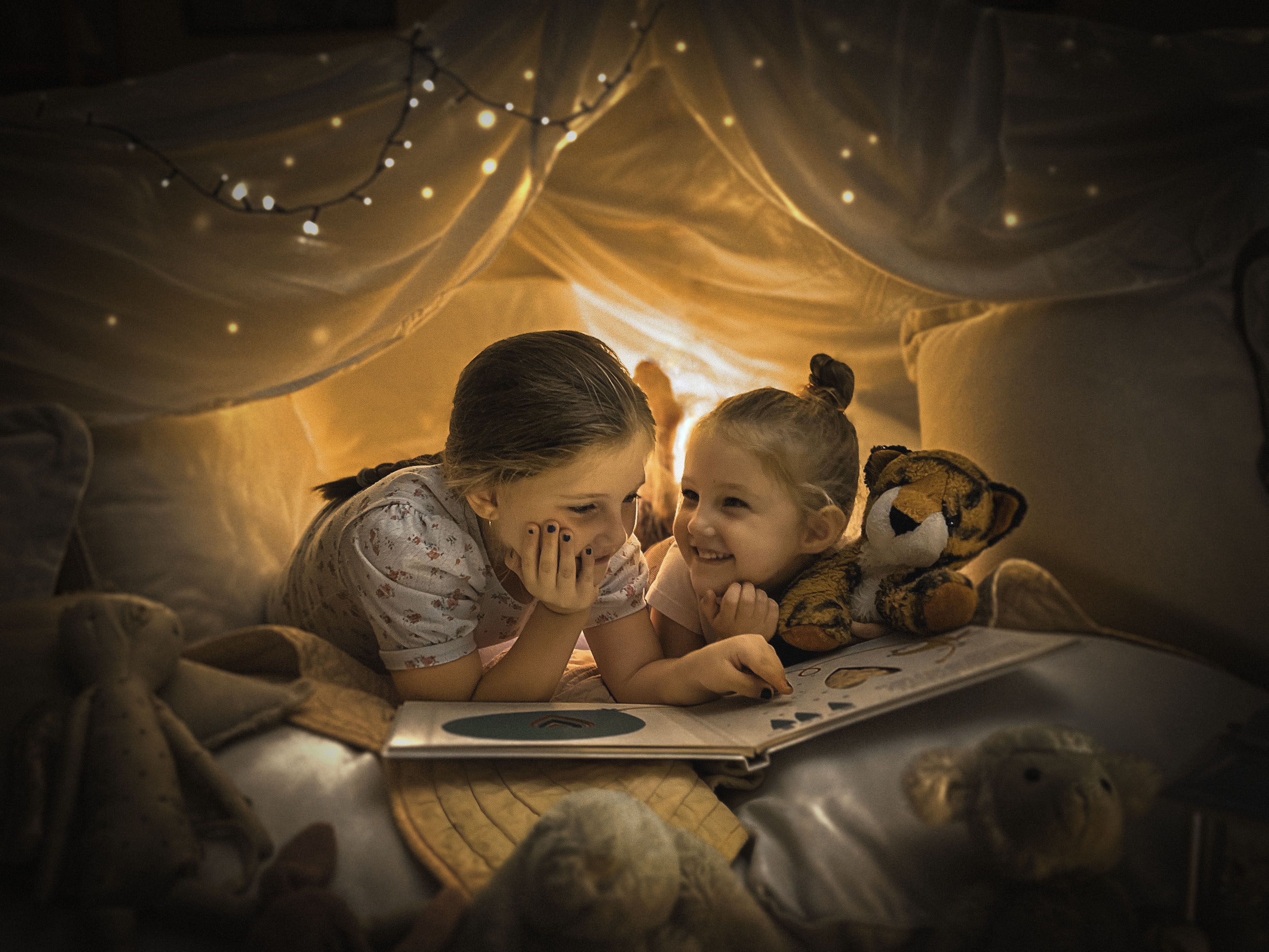 Two children in a cubby reading